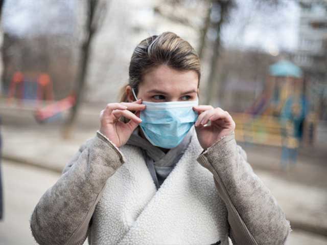 Woman wearing a surgical mask on her face | Filling Equipment